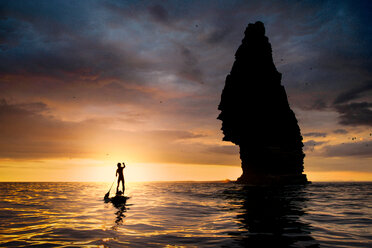 Paddelboardfahrer auf dem Wasser bei Sonnenuntergang, neben dem Meeresstapel, Cliffs of Moher, Doolin, Clare, Irland - CUF44862