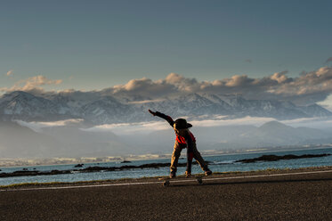 Junger Junge auf dem Skateboard entlang der Küstenstraße, Kaikoura, Gisborne, Neuseeland - CUF44871