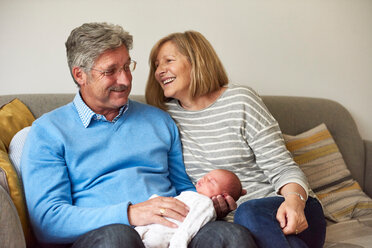Grandparents on sofa with baby granddaughter - CUF44916