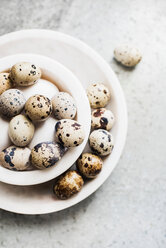 White and speckled eggs in bowls, overhead view - CUF44936