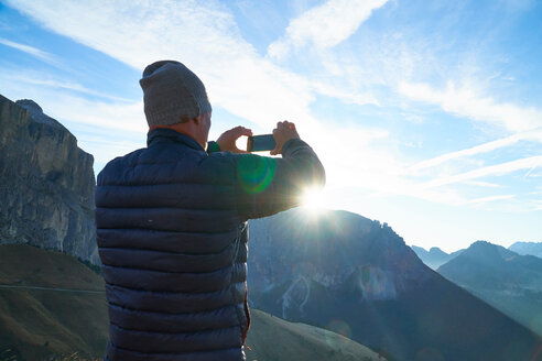 Hiker photographing of view of sunrise, Canazei, Trentino-Alto Adige, Italy - CUF44966
