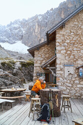 Hiker relaxing with cup of coffee, Canazei, Trentino-Alto Adige, Italy - CUF44970