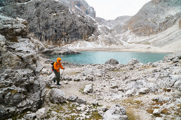 Hiker passing lake, Canazei, Trentino-Alto Adige, Italy - CUF44975