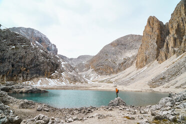Hiker admiring view by lake, Canazei, Trentino-Alto Adige, Italy - CUF44976