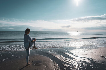 Frau übt Yoga am Strand - CUF44993