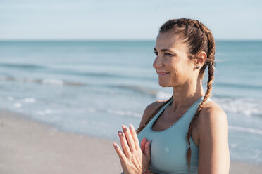 Woman practising yoga on beach - CUF44994