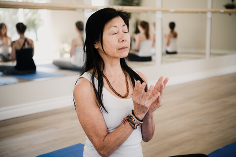 Frau in Yoga-Pose, Spiegel im Hintergrund, lizenzfreies Stockfoto