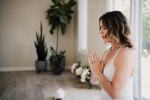 Woman with palms closed in meditation posture stock photo