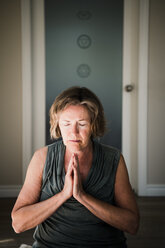 Frau mit geschlossenen Handflächen in Meditationshaltung - CUF45021