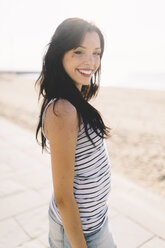 Porträt einer lächelnden jungen Frau mit Nasenpiercing an der Strandpromenade - GIOF04599