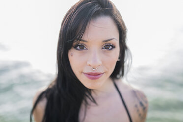 Portrait of smiling young woman with nose piercing at the sea - GIOF04634