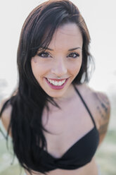 Portrait of smiling young woman with nose piercing at the sea - GIOF04635