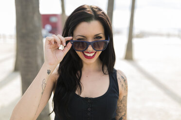 Portrait of twinkling young woman with nose piercing and sunglasses - GIOF04650