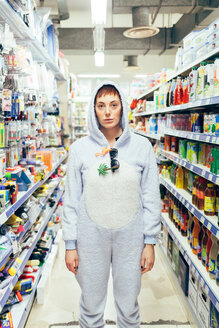 Porträt einer Frau in einem Bodysuit für Erwachsene auf einer Supermarktinsel, die in die Kamera schaut - CUF45136