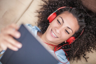 Frau hört zu Hause Musik auf einem digitalen Tablet - CUF45165