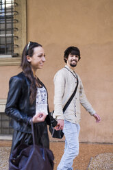 Portrait of happy young man walking hand in hand with his girlfriend - GIOF04664