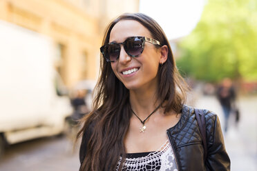 Porträt einer lächelnden jungen Frau mit Sonnenbrille - GIOF04672