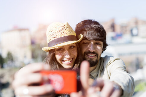 Porträt eines glücklichen jungen Paares, das ein Selfie mit einem Smartphone macht - GIOF04695