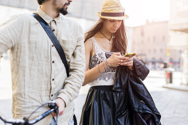 Junge Frau mit Smartphone in der Stadt - GIOF04709