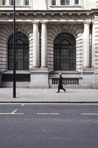 UK, London, älterer Geschäftsmann geht auf Bürgersteig, lizenzfreies Stockfoto