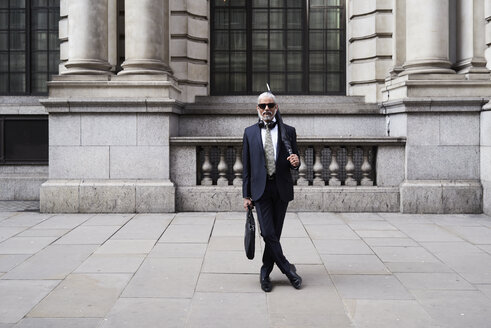 UK, London, portrait of stylish businessman with sunglasses and umbrella wearing suit and tie - IGGF00619