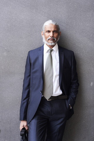 Porträt eines älteren Geschäftsmannes mit grauem Haar und Bart, der Anzug und Krawatte trägt, lizenzfreies Stockfoto
