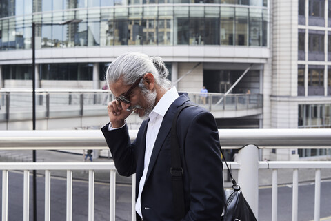 Grauhaariger älterer Geschäftsmann beim Telefonieren, lizenzfreies Stockfoto