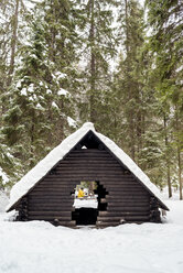 Finland, Kuopio, woman preparing campfire in winter - PSIF00111