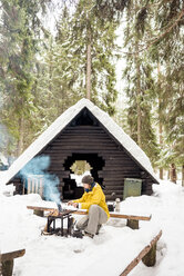 Finland, Kuopio, woman preparing campfire in winter - PSIF00112