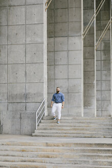 Bärtiger Hipster-Geschäftsmann geht die Treppe hinunter - FMGF00017