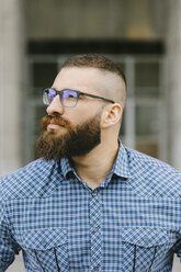 Portrait of bearded hipster businessman wearing glasses and plaid shirt - FMGF00031