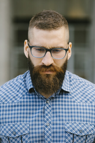 Porträt eines bärtigen Hipster-Geschäftsmannes mit Brille und kariertem Hemd, lizenzfreies Stockfoto
