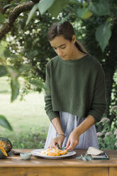 Young woman garnishing homemade pumpkin gnocchi - ALBF00616