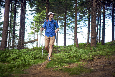 Lächelnder Mann beim Wandern im Wald - BSZF00663