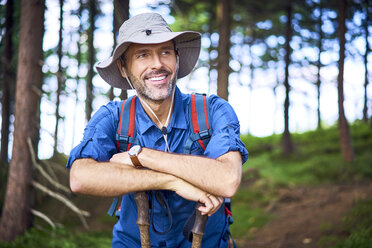 Lächelnder Mann, der eine Pause vom Wandern im Wald macht - BSZF00664