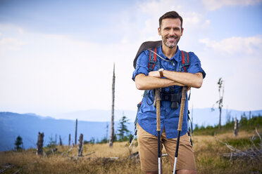 Porträt eines lächelnden Mannes, der eine Pause vom Wandern in den Bergen macht - BSZF00689