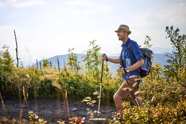 Smiling man hiking in the mountains - BSZF00711