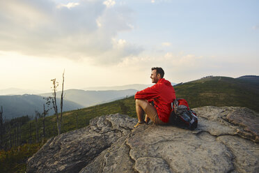 Man sitting on rock enjoying the view during hiking trip - BSZF00729