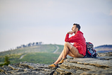 Man sitting on rock enjoying the view during hiking trip - BSZF00734