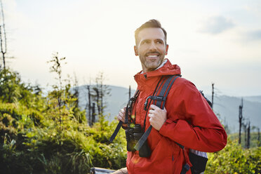 Porträt eines lächelnden Mannes beim Wandern in den Bergen - BSZF00739