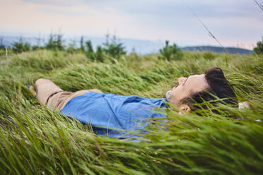 Entspannter Mann im Gras liegend - BSZF00748