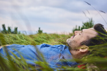 Relaxed man lying in grass - BSZF00749