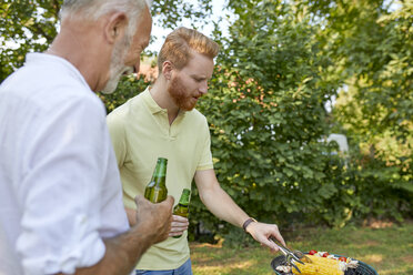 Senior father and adult son having a barbecue in garden - ZEDF01582