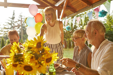 Happy couple with parents having a garden party - ZEDF01614