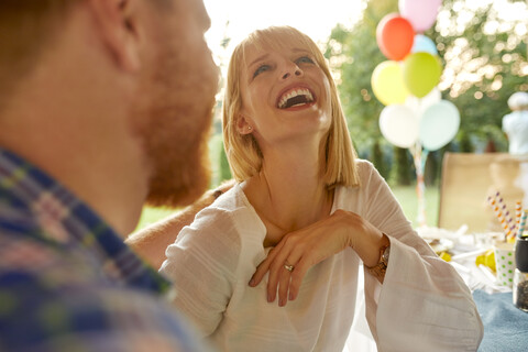 Lachende Frau mit Mann auf einer Gartenparty, lizenzfreies Stockfoto