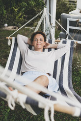 Portrait of smiling woman lying in a hammock - HMEF00019