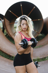 Athletic woman doing weight workout at industrial site - FMGF00045