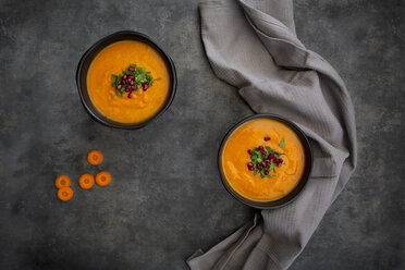 Bowl of carrot ginger coconut soup with topping of parsley and pomegranate seed - LVF07453