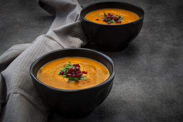 Bowl of carrot ginger coconut soup with topping of parsley and pomegranate seed - LVF07455