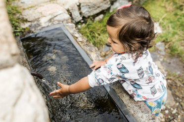 Kleines Mädchen spritzt mit Wasser am Brunnen - VABF01627